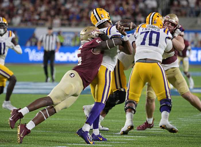 SU Tigers quarterback Jayden Daniels (5) is sacked by Florida State Seminoles defensive end Jared Verse (